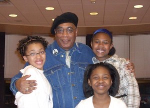 Photo of Larry Pinkney with 3 young audience members